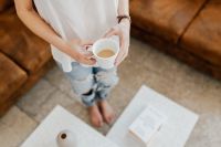 Kaboompics - A woman with a cup of coffee reads a book