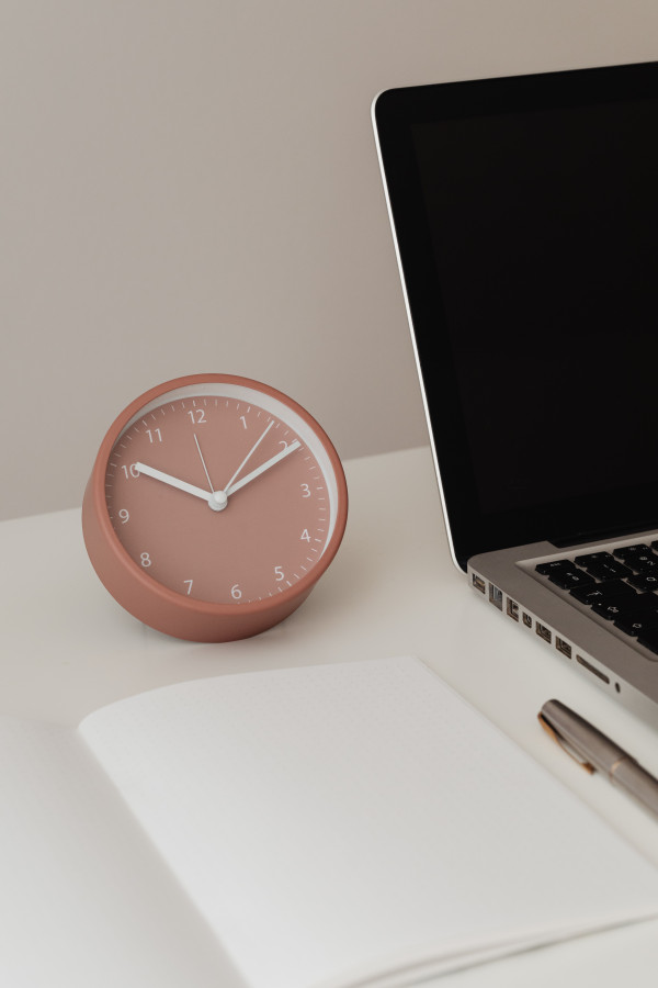 Detail of desk with laptop - supplies - notepad - clock - time - pen ...