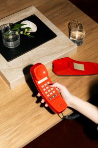 Kaboompics - Retro Red Telephone And Glass On Minimal Coffee Table