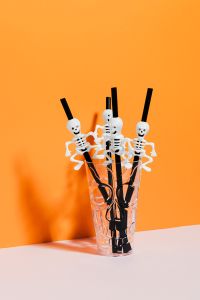 Kaboompics - Halloween Skeleton Straws in Glass on Orange Background