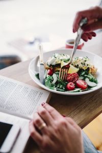 Kaboompics - Woman eating breakfast and reading a book