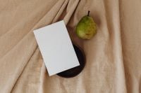 Kaboompics - Blank Business Card and Green Pear beside a Round Wooden Plate