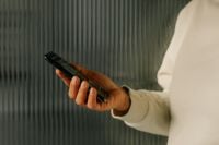 Kaboompics - Close-Up of Woman’s Hand Holding Smartphone Against Ribbed Wall