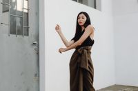 Kaboompics - Asian Fashion Model with Arms Extended in Black Top and Brown Wrap Skirt