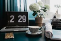 Kaboompics - Workspace with Laptop Screensaver, Potted Hydrangea, Coffee and a Rolled Magazine