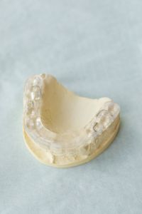 Kaboompics - Clear Dental Appliance on Plaster Cast With Blue Copy Space
