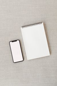 Kaboompics - Phone and Open Spiral Notebook Mockup on a Beige Sofa