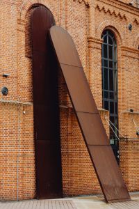 Kaboompics - Sculptural Brown Metal Wall Feature on Manufaktura’s Red-Brick Facade, Łódź