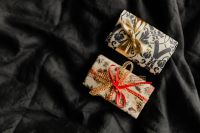 Kaboompics - Kraft Gift Box with a Red Bow on Dark Bedding