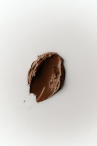Kaboompics - Dark Brown Foundation Cream Swatch on White Background, Clean Cosmetic Makeup Texture for Beauty Product Design