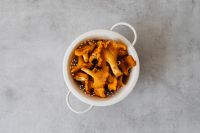 Kaboompics - Chanterelle Mushrooms in White Colander on Light Surface