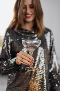 Kaboompics - Smiling Woman in a Black Sequin Dress with Champagne Coupe, Celebration Portrait