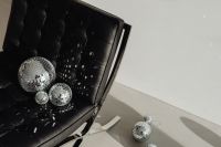 Kaboompics - Disco Ball Decor, Glass Bottle and Party Streamers on a Black Leather Chair