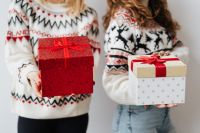 Kaboompics - Two Women Holding Christmas Gifts in Festive Sweaters