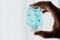 Kaboompics - Small Blue Sanitizer Bottle Held Between Fingers