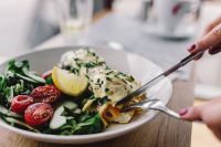 Kaboompics - Close up image of young woman eating classic breakfast at restaurant