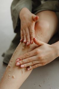 Kaboompics - Hands Spreading Exfoliating Body Scrub along the Leg