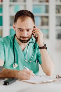 Kaboompics - Doctor Taking Notes During Phone Consultation