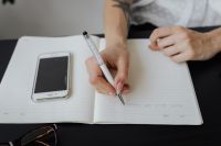 Kaboompics - Planning the Workday in an Open Notebook at Office