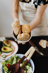 Kaboompics - Hands Holding Bread Rolls over a Salad Bowl on Kitchen Table