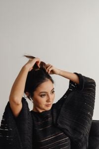 Kaboompics - Close-Up of a Woman Adjusting Her Hair in a Black Knit Top