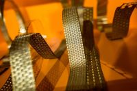 Kaboompics - Bended golden metal on an orange background