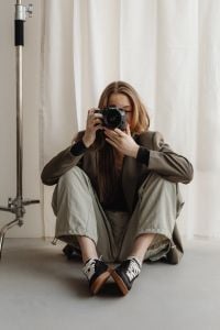 Kaboompics - Seated Young Female Photographer Shooting with DSLR Camera