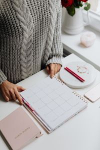 Kaboompics - Woman Pointing to a Date in a Calendar Beside Pink Pens