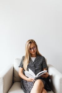 Kaboompics - Young Woman Reading Book in Armchair