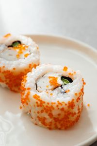 Kaboompics - Vertical Tobiko Maki Rolls on White Plate with Copy Space