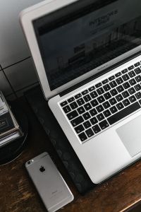 Front view of laptop and mobile phone on the wooden desk
