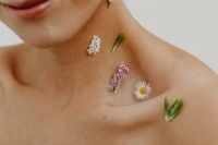 Kaboompics - Beauty Crop of Wildflower Sprigs and a Daisy Arranged on Bare Neck and Chest