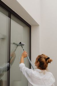 Kaboompics - Woman Cleaning a Glass Window in a Bright Living Room