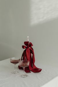 Kaboompics - White Candles with Red Ribbons and Cocktail Glasses