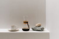 Kaboompics - Minimal Chemex, Coffee Cup and Stones on White Pedestal