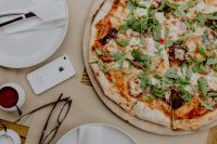 Kaboompics - Overhead Pizza Dinner with Phone, Cutlery and Tomato Dip