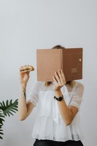 Kaboompics - Freelancer Holding Burger and Planner During Lunch Break