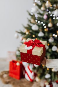 Kaboompics - Red and Gold Christmas Gift in Front of a Decorated Tree
