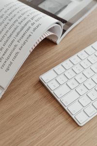 Kaboompics - Open Book and White Keyboard on Oak Desk, Minimal Home Office Detail
