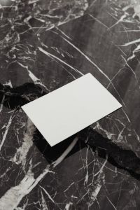 Kaboompics - Angled Blank Business Card at the Bottom of a Vertical Black Marble Background