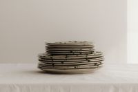 Kaboompics - Two Green Splatter Plate Stacks on a Linen Table