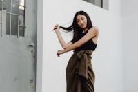 Kaboompics - Asian Woman in Black Top and Brown Skirt Posing beside White Wall