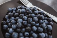 Kaboompics - Fresh blueberries on a black plate with vintage cutlery