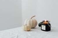 Kaboompics - White Pumpkins and Black Candle on a White Table