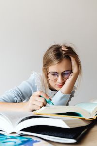 Kaboompics - Student Doing Homework among Open Books