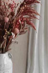 Kaboompics - Dried Pink Bouquet In White Ceramic Vase With Curtain Copy Space
