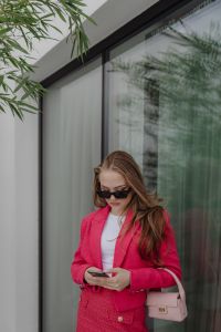 Kaboompics - Woman Using a Smartphone with a Pink Handbag