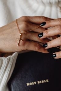 Kaboompics - Close-Up of Gold Cross Pendant and Hands on a Bible