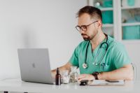 Kaboompics - Doctor Reviewing Laptop at Clinical Office Desk