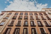 Kaboompics - Wide Madrid Apartment Facade with Repeating Iron Balconies Beneath Clouds
